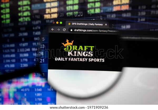 KAUFBEUREN,\
GERMANY - APRIL 27, 2021: Draft Kings company logo on a website\
with blurry stock market developments in the background, seen on a\
computer screen through a magnifying\
glass.