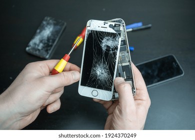 Kaunas, Lithuania - February 24, 2021: Broken Iphone. Screen cracked mobilephone. Repairing  Iphone smartphone touchscreen. Replacing screen and battery