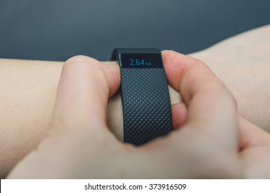 KAUNAS, LITHUANIA - FEBRYARY 06, 2016: Holding activity tracker (Fitbit Charge HR), isolated on black background