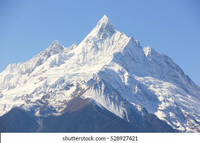 Kawagarbo snow mountain on a blue sky in Deqin, Yunnan province, China. Summit, peak of sharp snowcapped mountain. Unreachable, challenge concept
