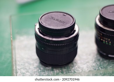 Kawasaki, Japan - May 2014: Close Up View Of Old Canon Prime Lenses With Mount Cap On Glass Table. No People.