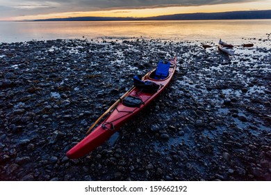 Kayak Beached On Rocky Shore In Alaska At Sunset In Summer