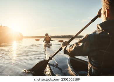 Kayak, lake and people rowing a boat on the water during summer for recreation or leisure at sunset. Nature, view and horizon with people canoeing for adventure, freedom or travel while on vacation