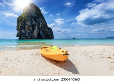 A kayak lying at the popular Phra Nang Cave Beach at Railey, Krabi, Thailand, with fine sand and emerald sea, corals and steep limestone cliffs - Powered by Shutterstock