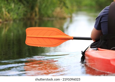 Kayak Oar Above Water Surface Close-up. River Kayaking In Summer Day Concept. Active Vacations.