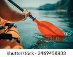 Kayak paddle sea vacation. Person paddles with orange paddle oar on kayak in sea. Leisure active lifestyle recreation activity rest tourism travel