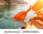 Kayak paddle sea vacation. Person paddles with orange paddle oar on kayak in sea. Leisure active lifestyle recreation activity rest tourism travel.