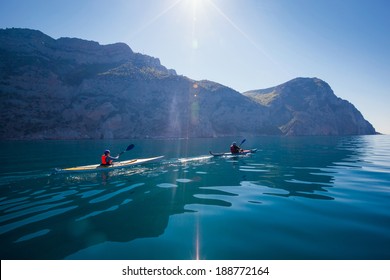 Kayak. People kayaking in the sea near the mountains. Activities on the water. - Powered by Shutterstock