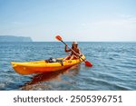 Kayak sea woman. Happy attractive woman with long hair in red swimsuit, swimming on kayak. Summer holiday vacation and travel concept.