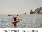 Kayak sea woman. Happy attractive woman with long hair in red swimsuit, swimming on kayak. Summer holiday vacation and travel concept.