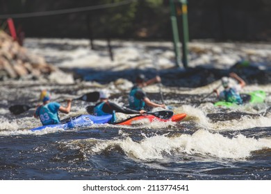 Kayak Slalom Canoe Race In White Water Rapid River, Process Of Kayaking Competition With Multiple Colorful Canoe Kayak Boat Paddling, Process Of Canoeing With Big Water Splash