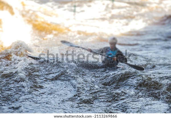 Kayak slalom canoe race in
white water rapid river, process of kayaking competition with
colorful canoe kayak boat paddling, process of canoeing with big
water splash