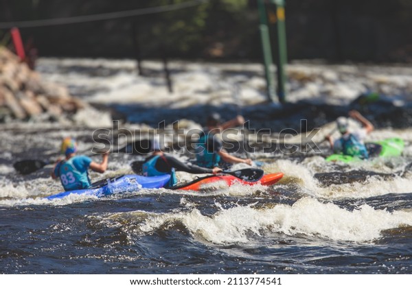 Kayak slalom\
canoe race in white water rapid river, process of kayaking\
competition with multiple colorful canoe kayak boat paddling,\
process of canoeing with big water\
splash