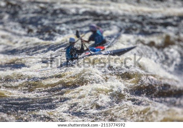 Kayak slalom\
canoe race in white water rapid river, process of kayaking\
competition with multiple colorful canoe kayak boat paddling,\
process of canoeing with big water\
splash