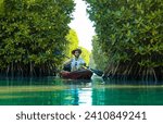 Kayak through green mangrove forest lake, Tourist guy kayaking in Kavvayi Island Kannur, Kerala backwater image, Travel and tourism concept photography