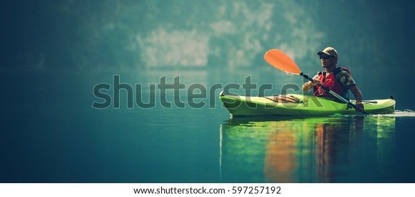 Kayak Water Sports Banner with Copy\
Space. Senior Kayaker on the Scenic Lake Panoramic\
Photo.