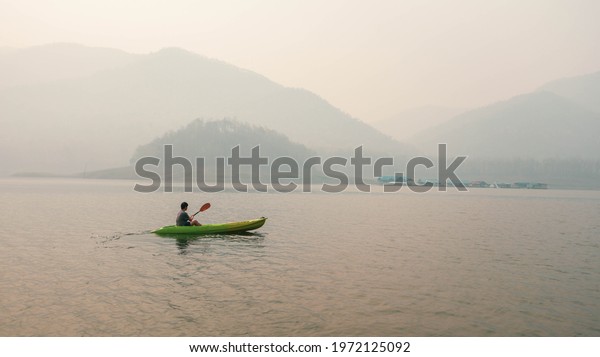 Kayak Water Sports at Lake. Kayakers enjoying the\
beautiful sunrise walks by sea kayak or canoe at tropical bay.\
relaxing with boat