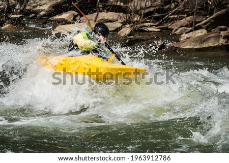 Kayaker going down class three whitewater in rural Tennessee 