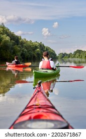 Kayaker Point Of View. Kayak Bow With A View On The River Green Trees And Two Kayakers. River Kayaking Concept. Active Vacations In Wild Nature