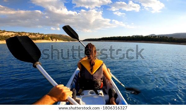 Kayakers rowing at lake. Pov of woman kayaking\
in beautiful landscape at Embalse de la Bolera, Spain. Aquatic\
sports in kayak during summer\
concept.