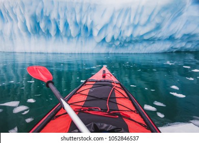 Kayaking In Antarctica, Red Canoe Boat With Paddle  Near Blue Iceberg