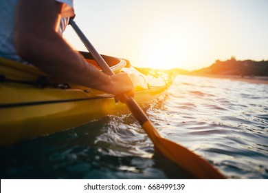 Kayaking. Close Up Of Man Holding Kayak Paddle At Sunset Sea