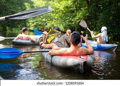 Kayaking. Group of friends relax on canoe in wild river. Sport tourism in jungle river. Leisure activity. Swim in kayak. People swimming in boats.