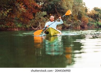 Kayaking On The River. Adult Caucasian Bearded Man Floating At The Kayak. Copy Space. The Concept Of The World Tourism Day.