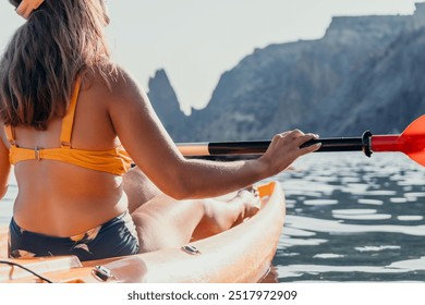 Kayaking Woman Mountains Water - A woman kayaks on a lake with mountains in the background. - Powered by Shutterstock