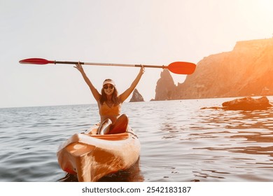 Kayaking Woman Ocean Adventure: Happy woman paddles kayak on calm water with rocky cliffs in the background. - Powered by Shutterstock