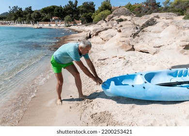 Kayaking.Happy Mature  Couple Pulling Out Kayak To The Sea. Leisure Activities On The Sea.