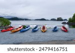 Kayaks on the shore of Sitka Sound, Rockwell Lighthouse in the distance. Sitka. Alaska.