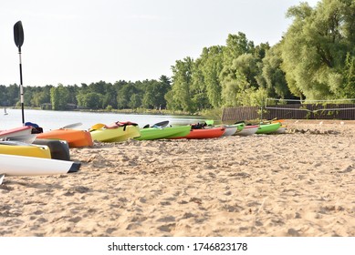 Kayaks Stand On A Sandy Beach. Colorful Kayaks On The Michigan Beach. Lake Hyron. Kayaks Sport Time. Summer Activities For Family. Top View. Space For Text.