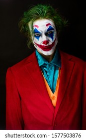 KAZAKHSTAN, KOSTANAY - OCTOBER 21, 2019: Man impersonating the Joker. Portrait of a man in a suit with clown makeup and green hair. Joker cosplay.