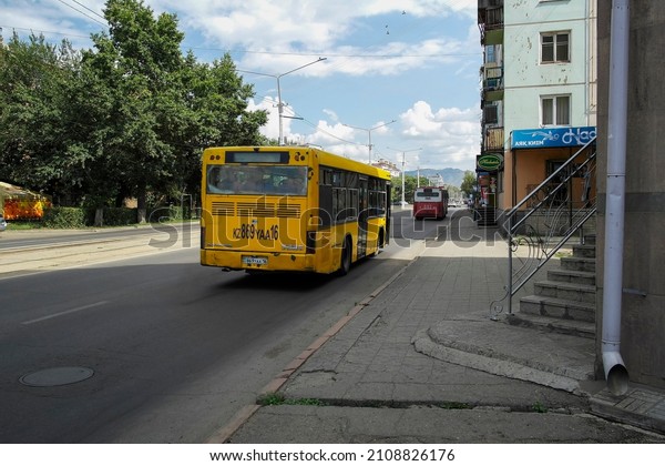 kazakhstan, Ust-Kamenogorsk, july 31, 2021: One of\
the city streets. Summer cityscape. Two buses. Public transport.\
Yellow and red\
buses