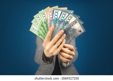 Kazakhstan various denominations money tenge in hands against the background of a woman in gray jacket. - Shutterstock ID 2069317250