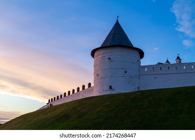 Kazan old Kremlin with white brick walls and towers in the evening in pink lighting.