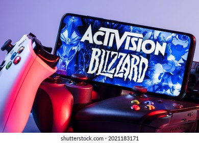 Kazan, Russia - August 7, 2021:  Activision Blizzard, Inc. is an American video game holding company. A smartphone with the Activision Blizzard logo on the screen on the pile of the gamepads.