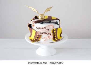 KAZAN, RUSSIA -  February, 12, 2022: Cake In The Form Of Harry Potter Tools. Magic Wand, Hat, Glasses, Book, Golden Snitch. Hogwarts