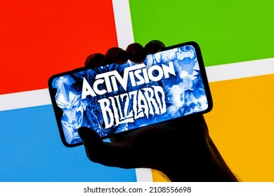 Kazan, Russia - Jan 18, 2022: Activision Blizzard logo on smartphone screen in hand against background of Microsoft logo. Microsoft announced buying of video game publisher Activision Blizzard.