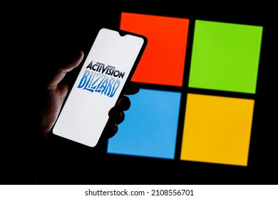 Kazan, Russia - Jan 18, 2022: Activision Blizzard logo on smartphone screen in hand against background of Microsoft logo. Microsoft announced buying of video game publisher Activision Blizzard.