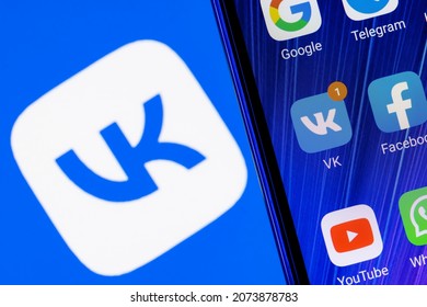 Kazan, Russia - Nov 13, 2021: The icon of the VKontakte social network application among other applications on the smartphone screen. On the background is the VKontakte logo.