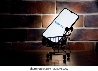 Kazan, Russia - Oct 20, 2021: Walmart is an American multinational retail corporation. Smartphone with Walmart logo on screen in the shopping cart.