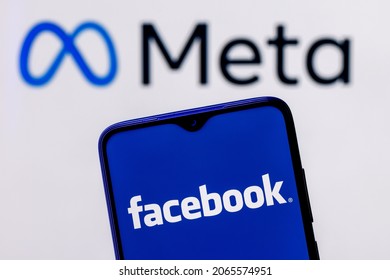 Kazan, Russia - Oct 28, 2021: Facebook changes its name to Meta. Smartphone with Facebook logo on the background of Meta logo.