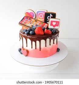 KAZAN, RUSSIA -  October, 8, 2020: Cake With Chocolate, Decorated With Strawberries, Blueberries, 
Gingerbread Cookies With A Smartphone, Instagram, Likee, TikTok Logos