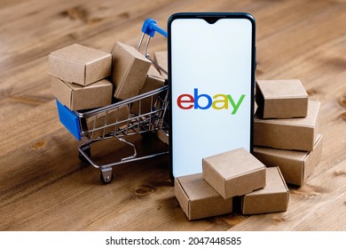 Kazan, Russia - Sep 25, 2021: eBay is an e-commerce corporation that offers online shopping, auction and marketplace services. Smartphone with eBay logo on the screen, shopping cart and parcels.