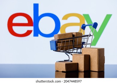Kazan, Russia - Sep 25, 2021: eBay is an e-commerce corporation that offers online shopping, auction and marketplace services.  Shopping cart with parcels on the background of the eBay logo.
