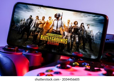 Kazan, Russia - September 01, 2021: PlayerUnknown Battlegrounds (PUBG) is an online multiplayer battle royale game. A smartphone with the frame from PUBG Mobile on the pile of the gamepads.