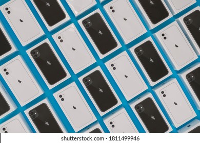Kazan, Russia - September 04, 2020: Pattern of many new unopened boxes with iPhone 11 in white and black on a blue background, top view, flatley.