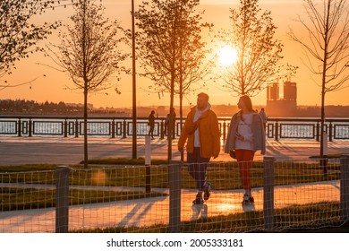 Kazan, Russia - September 12, 2020: A young man and a woman are walking on a sunny autumn evening by the river on the city embankment